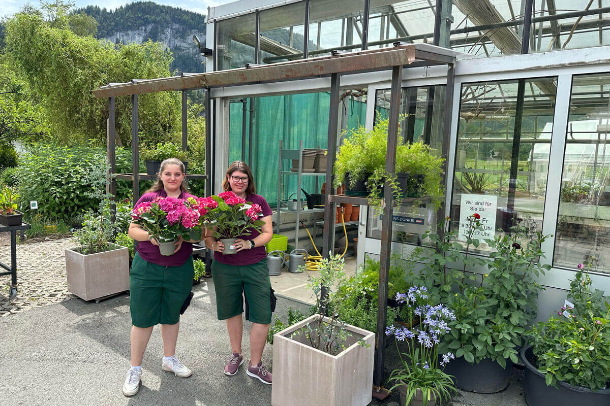 Zwei Jugendliche aus dem Gartencenter dekorieren das neue Vordach am Campus von oberrainanderskompetent